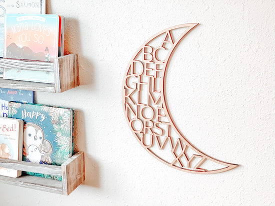 wooden alphabet moon nursery decor outlet next to wooden shelves filled with books