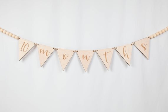 Custom banner, pennant flags with wooden beads on a white wall.
