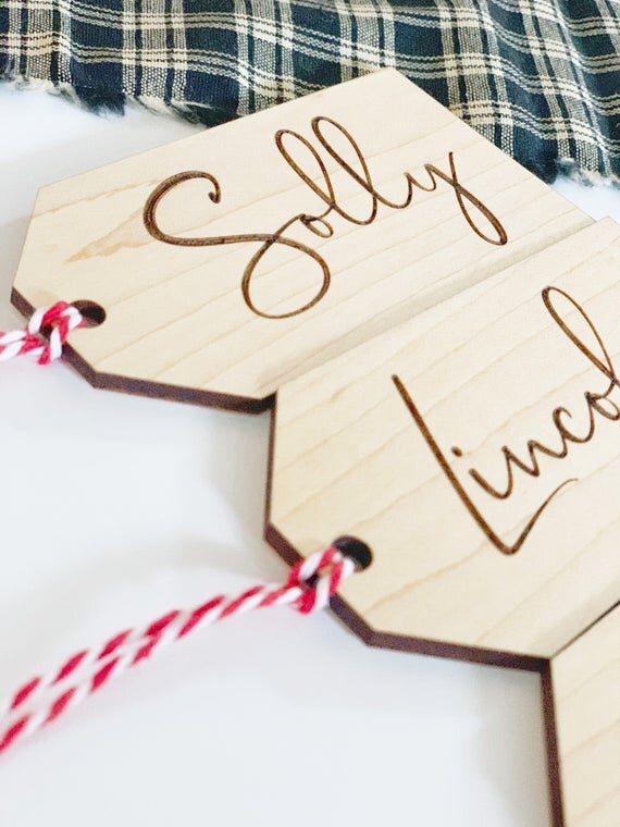 3.5" personalized wooden tags with red string next black and white plaid cloth