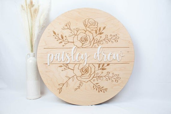 Baby Girl Nursery Sign with Floral Engraved Details next to botanical plant