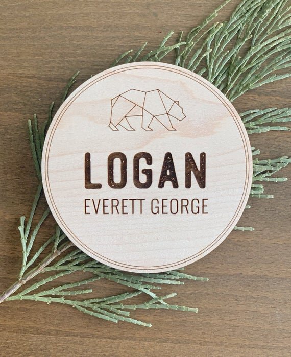 Bear Personalized Baby Name Announcement next to pine needle decor.
