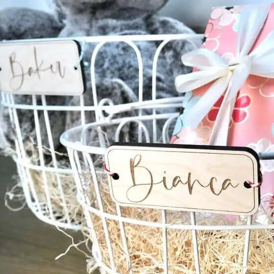 Custom wooden gift tags, custom name tags for Easter baskets, on two white wired baskets.
