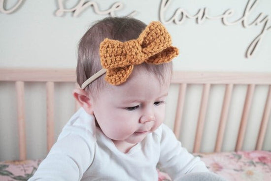 Load image into Gallery viewer, Crochet hair bow with head band on baby in her crib with isn&amp;#39;t she lovely wall decor.
