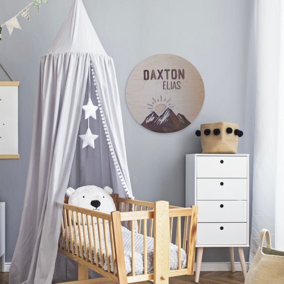 Custom mountain name sign hanging in a baby boys nursery room.