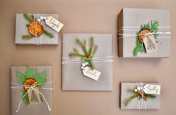 3.5" personalized wooden tags with wooden beads on gray wrapped Christmas gifts