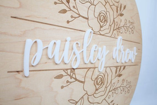 Baby Girl Nursery Sign with Floral Engraved Details above crib.