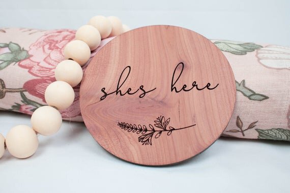 Load image into Gallery viewer, She&amp;#39;s here red cedar wood birth announcement circle with botanical decor
