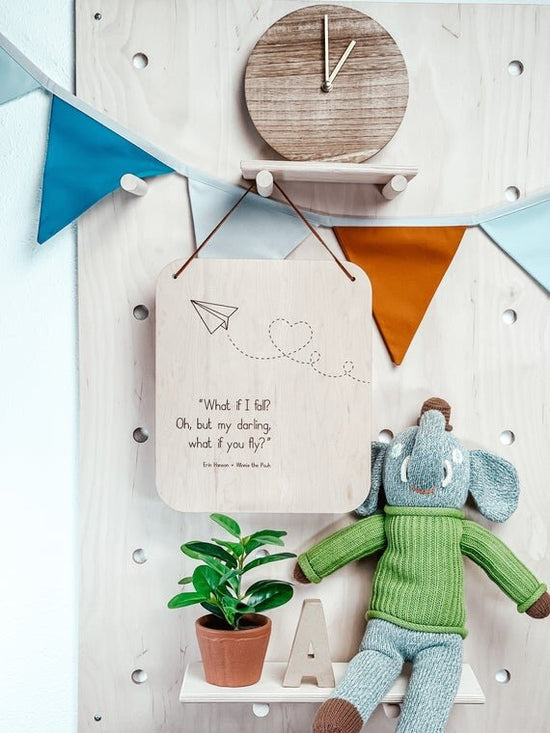 What if I fall nursery wall decor hanging on wooden peg board with green plant, elephant toy, and wooden clock
