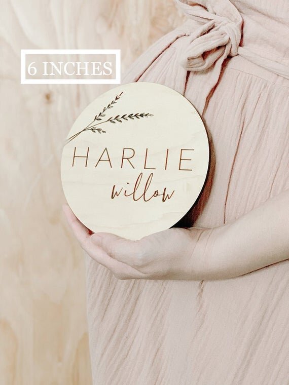 6 inch Botanical engraved wooden baby sign being held by pregnant mother.