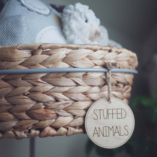 Load image into Gallery viewer, 3&amp;quot; circular wooden toy storage tags on a wicker basket filled with stuffed animals
